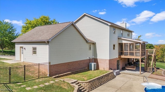 rear view of property with a patio and a sunroom