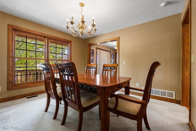 dining area featuring light carpet and a chandelier