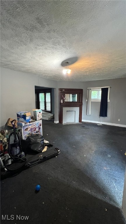 unfurnished living room with a textured ceiling, a healthy amount of sunlight, and a fireplace