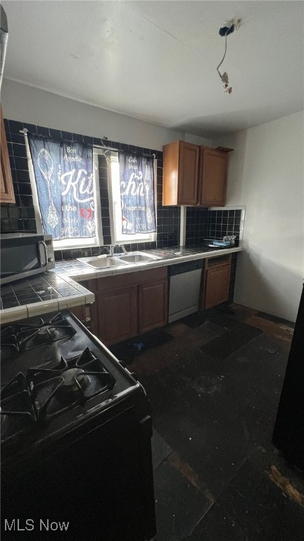 kitchen with decorative backsplash, tile countertops, appliances with stainless steel finishes, and sink