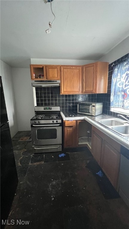 kitchen with backsplash, appliances with stainless steel finishes, and sink