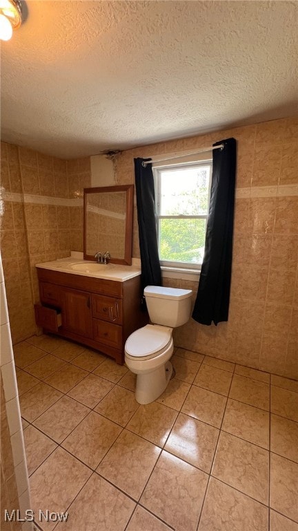 bathroom featuring tile walls, a textured ceiling, vanity, and toilet