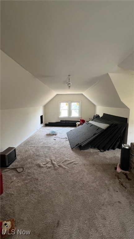 bonus room with vaulted ceiling and carpet flooring