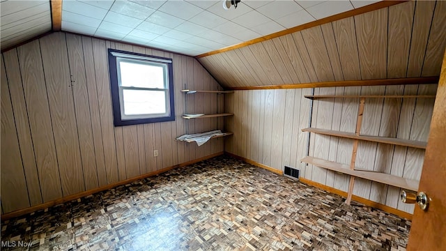 additional living space featuring lofted ceiling, wood walls, and parquet floors