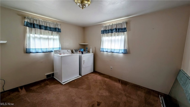 washroom featuring dark carpet, plenty of natural light, and washer and dryer