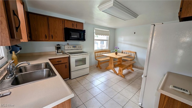 kitchen with white appliances, light tile patterned flooring, and sink