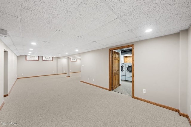 basement with a paneled ceiling, light carpet, and independent washer and dryer