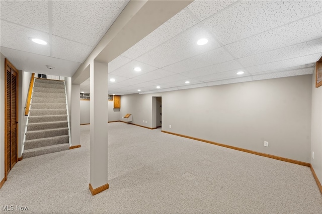 basement with light carpet and a drop ceiling