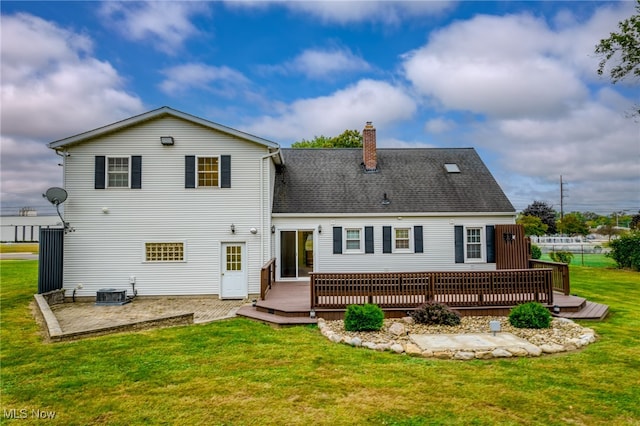 back of property with a lawn and a deck