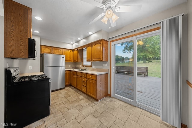 kitchen with black appliances, sink, and ceiling fan