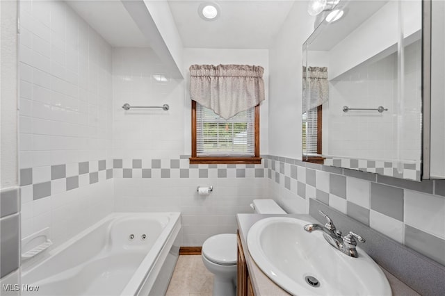 bathroom featuring tile walls, vanity, tile patterned flooring, a bath, and toilet