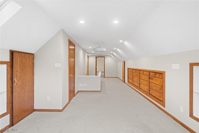 bonus room with vaulted ceiling with skylight and light carpet