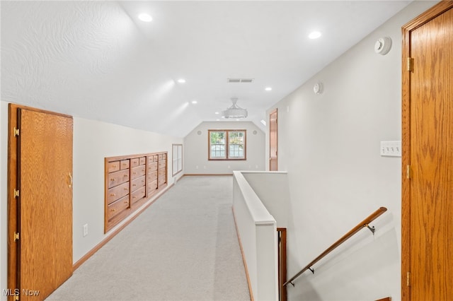 corridor featuring light carpet and vaulted ceiling