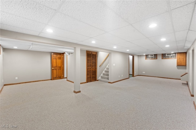 basement featuring a paneled ceiling and carpet