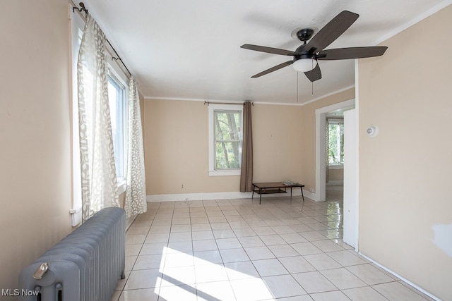 tiled empty room with ceiling fan, ornamental molding, and radiator heating unit