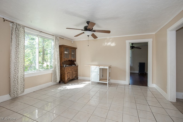 spare room with light tile patterned floors, crown molding, and ceiling fan