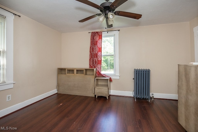 spare room with radiator heating unit, ceiling fan, dark wood-type flooring, and a textured ceiling