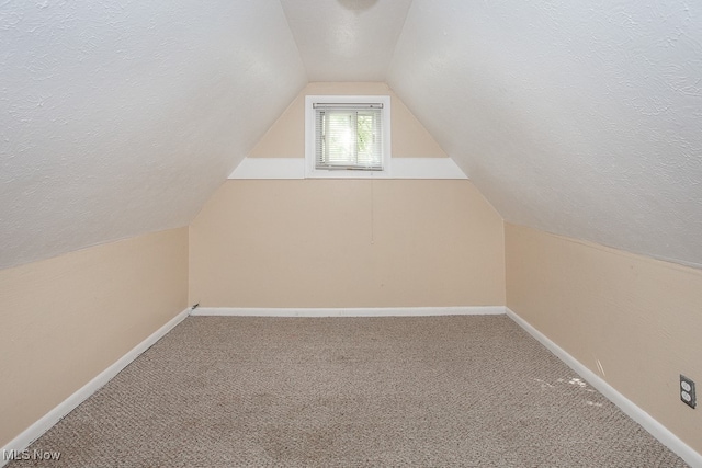 bonus room featuring lofted ceiling, a textured ceiling, and carpet floors