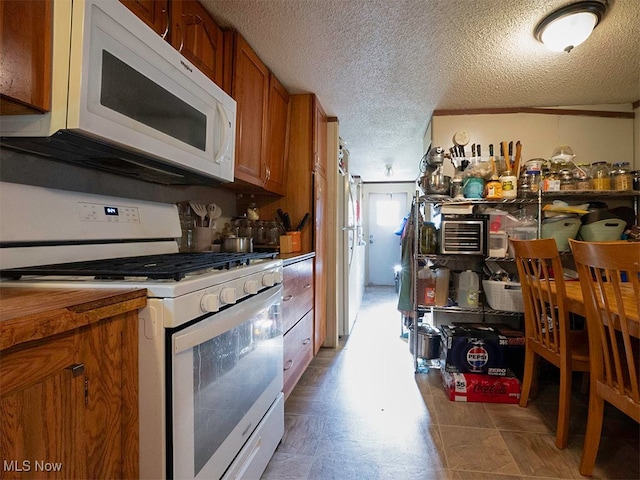 kitchen with white appliances and a textured ceiling