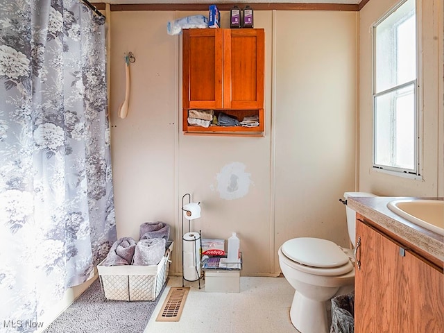 bathroom featuring walk in shower, vanity, and toilet