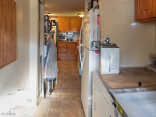 kitchen featuring white refrigerator and a textured ceiling