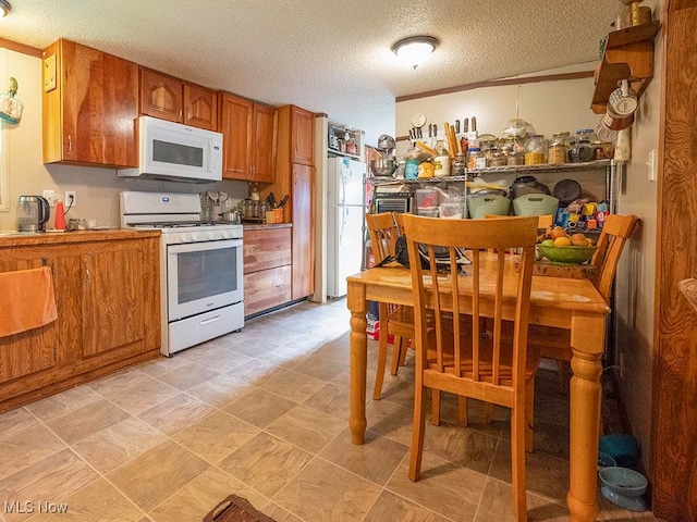 kitchen featuring a textured ceiling and white appliances