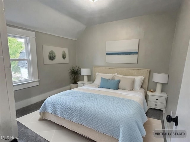 bedroom with lofted ceiling and tile patterned flooring