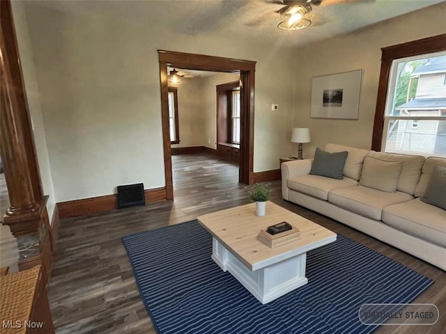 living room with ornate columns, ceiling fan, dark hardwood / wood-style floors, and a textured ceiling