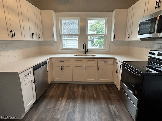 kitchen featuring stainless steel appliances, white cabinetry, dark wood-type flooring, and sink