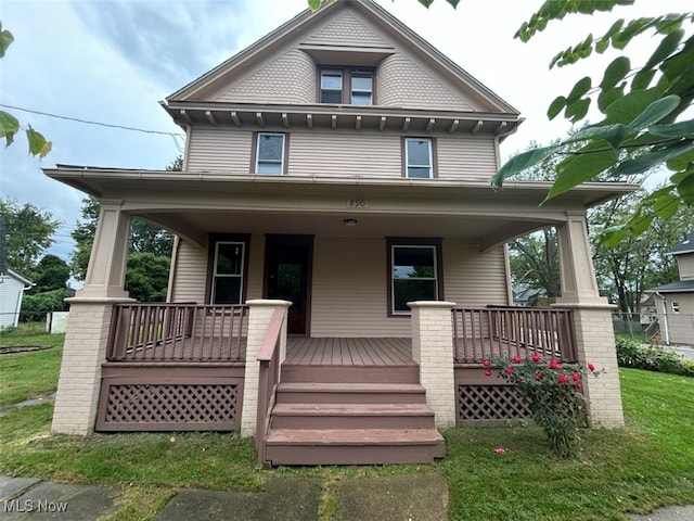 victorian home with a porch and a front lawn