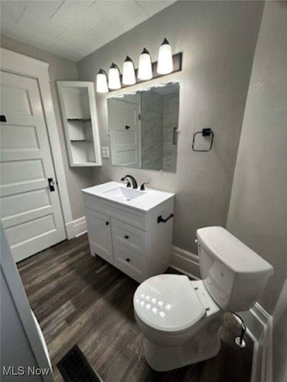 bathroom featuring wood-type flooring, vanity, and toilet