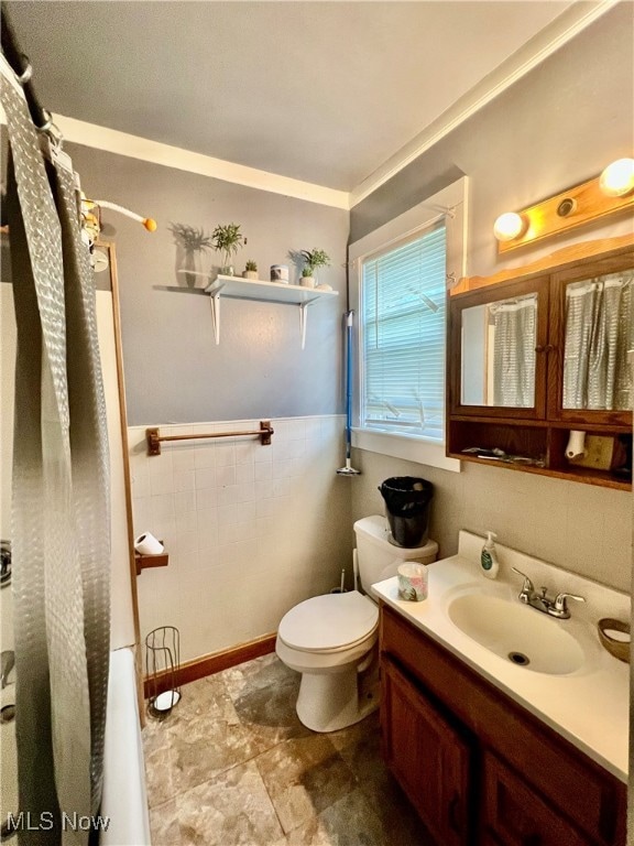 full bathroom with crown molding, shower / bath combo with shower curtain, vanity, and toilet