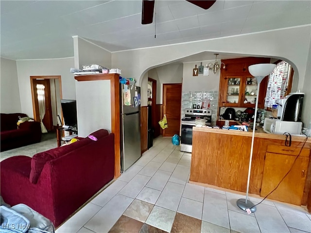 kitchen with decorative backsplash, light tile patterned floors, stainless steel appliances, and ceiling fan