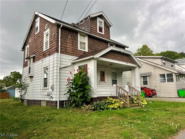 rear view of house featuring a porch and a yard