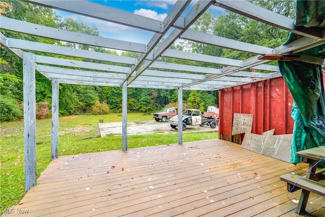 wooden terrace with a yard and a carport