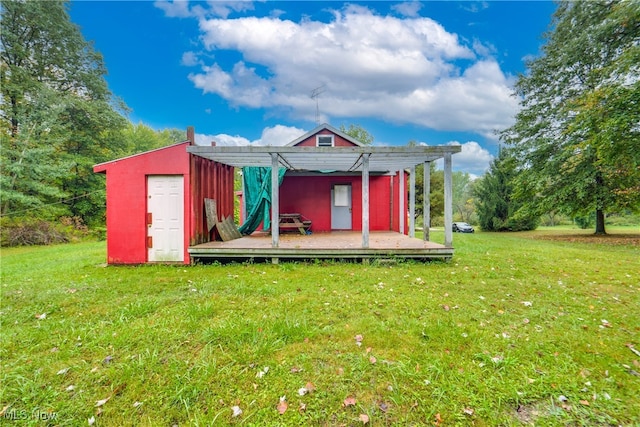 view of front of property featuring a shed, a pergola, a wooden deck, and a front yard