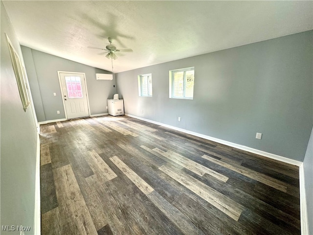 interior space with a healthy amount of sunlight, dark wood-type flooring, ceiling fan, and a wall unit AC