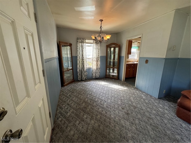 carpeted dining area featuring an inviting chandelier