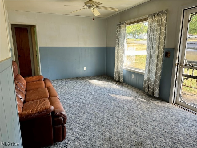 carpeted living room with ceiling fan