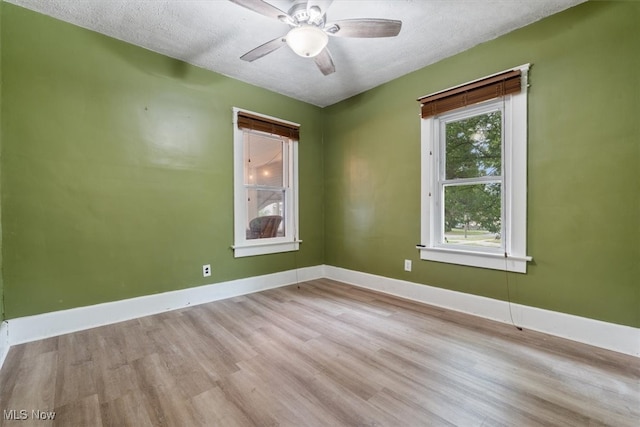 empty room featuring light wood-type flooring, a textured ceiling, and ceiling fan