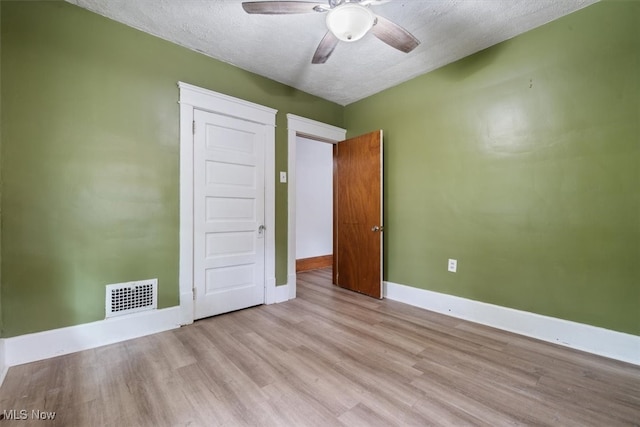 unfurnished bedroom featuring a textured ceiling, light hardwood / wood-style floors, and ceiling fan