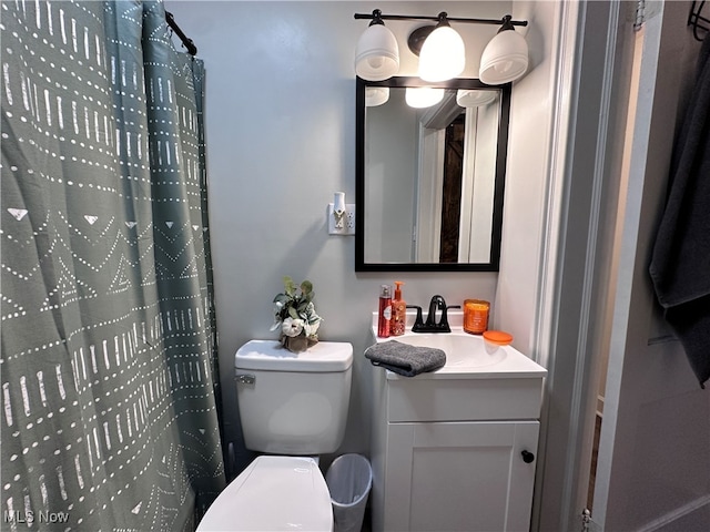 bathroom with curtained shower, vanity, and toilet