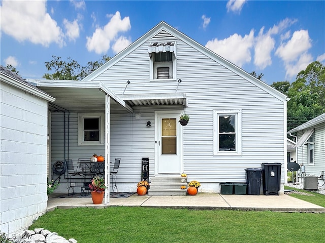 back of house featuring a lawn and central AC