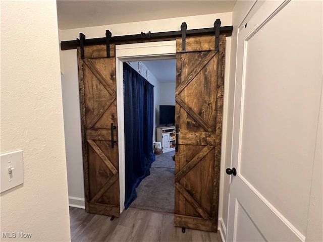 corridor with hardwood / wood-style floors and a barn door