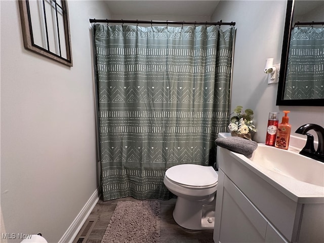 bathroom featuring wood-type flooring, a shower with curtain, vanity, and toilet