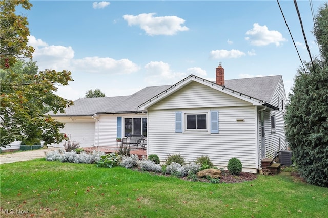 single story home with a garage, central air condition unit, and a front yard