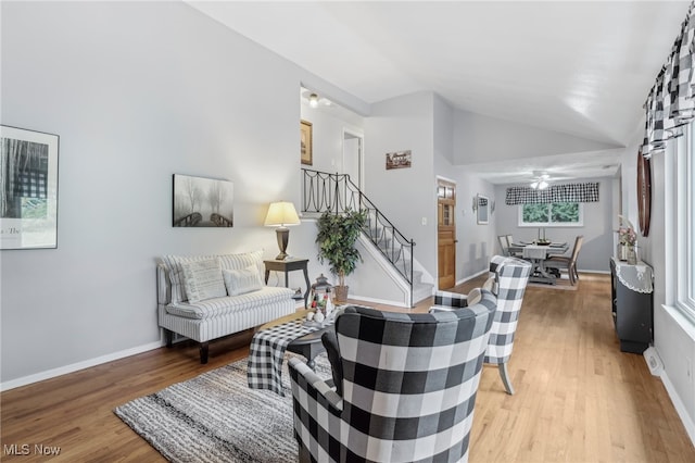 living room featuring light hardwood / wood-style floors, ceiling fan, and high vaulted ceiling