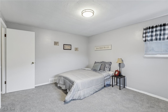 bedroom with a textured ceiling and carpet flooring