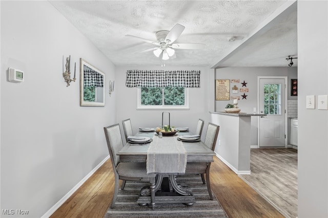 dining room with a textured ceiling, ceiling fan, and hardwood / wood-style flooring