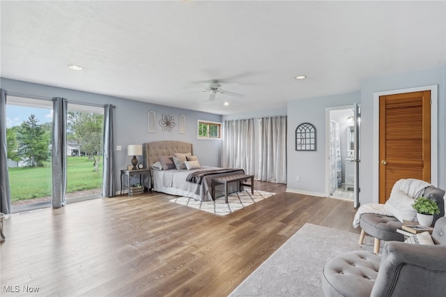 bedroom with connected bathroom, a closet, access to exterior, ceiling fan, and hardwood / wood-style floors